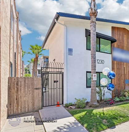 A modern house with a white and brown exterior and a black gate.