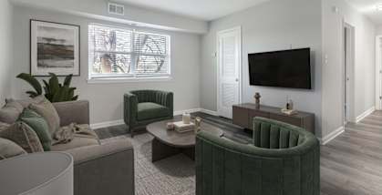 A living room with a green armchair and a grey sofa.