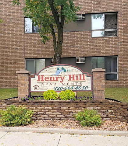 a sign apartments in front of a brick building