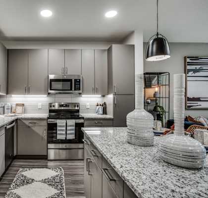 A modern kitchen with granite countertops and stainless steel appliances.