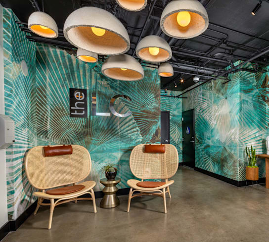 the interior of a hair salon with two chairs and a table with a mirror