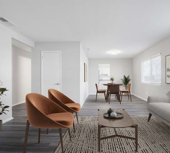 A living room with a grey couch, orange chairs, and a coffee table.