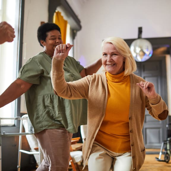 A group of elderly people dancing in a room.