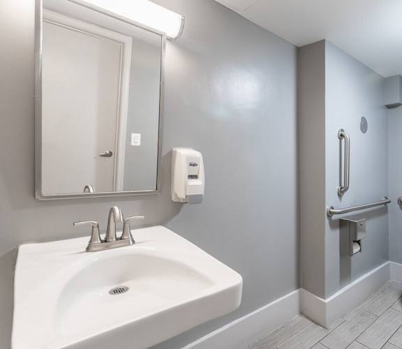 A bathroom with a white sink, toilet, and a mirror. at Charlestowne North Apartments, Maryland