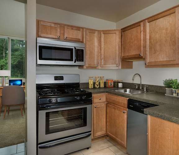 A kitchen with wooden cabinets and a black stove top oven. at Charlestowne North Apartments, Maryland