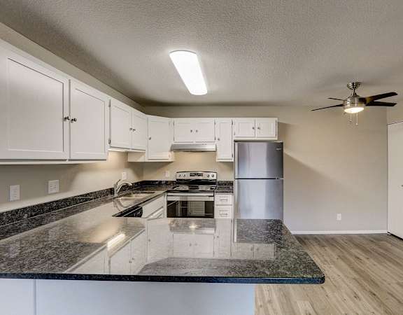 an open kitchen with granite counter tops and stainless steel appliances