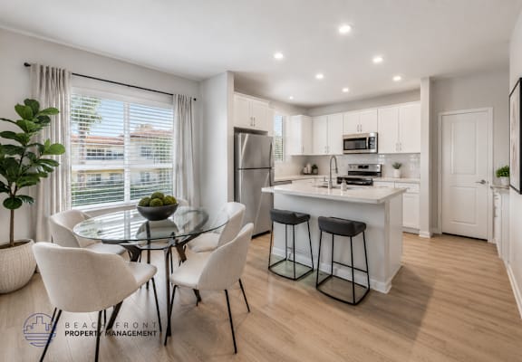 A modern kitchen with a dining table and chairs.