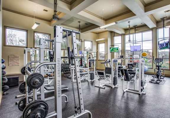 A gym with a variety of equipment including weights and machines.