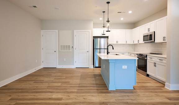 A kitchen with a blue island in the middle.