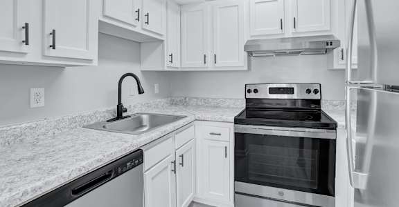 a kitchen with white cabinets and black appliances
