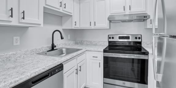 a kitchen with white cabinets and stainless steel appliances