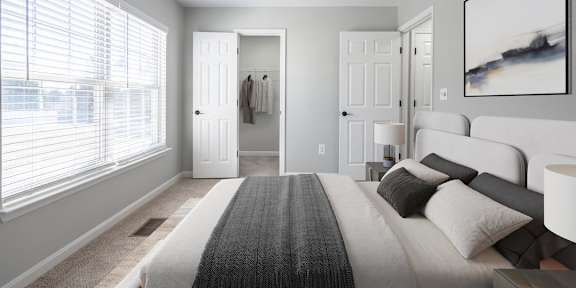 A bedroom with a large bed and a ceiling fan.