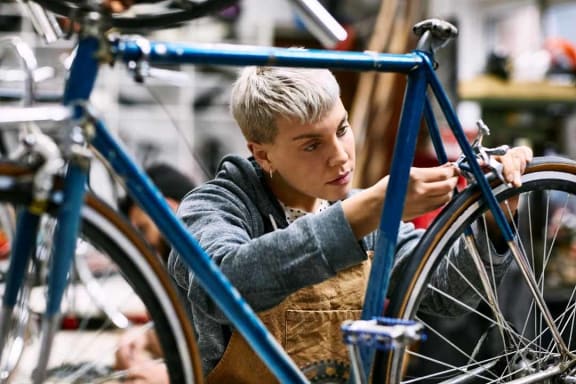 a young boy working on a bike in a workshop