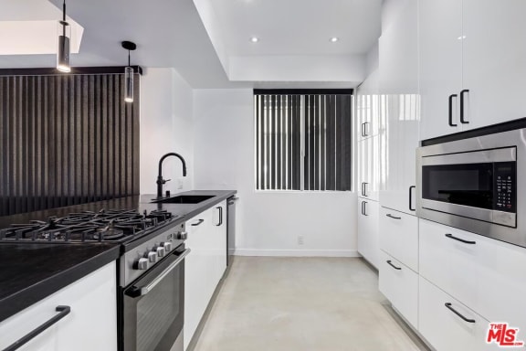 a kitchen with a stove top oven next to a microwave