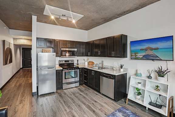 A kitchen with a refrigerator, stove, and microwave.