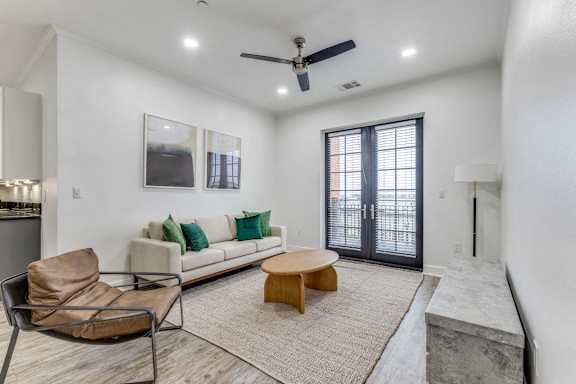 A living room with a brown chair, a white couch, and a rug.