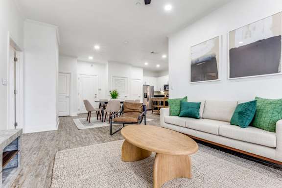 A living room with a white couch and a wooden coffee table.