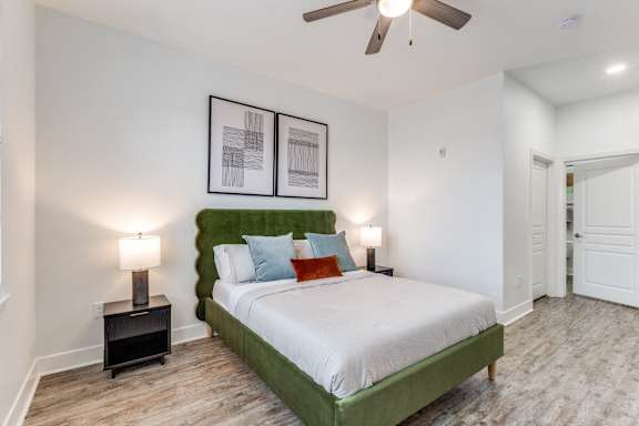 A bedroom with a green headboard and a white bed.