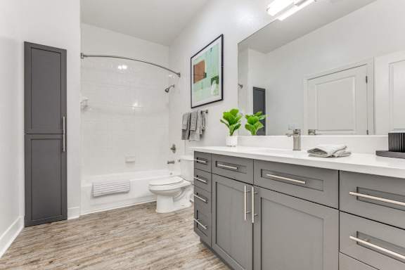 A bathroom with a toilet, sink, and a mirror.