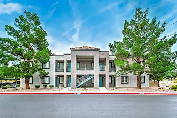A modern building with a flat roof and a balcony on the second floor.