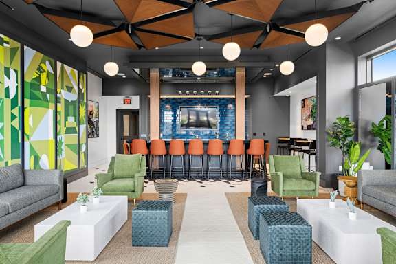 A modern living room with a bar area in the background.