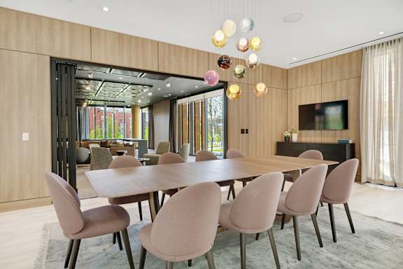 A modern dining room with a large table and chairs.