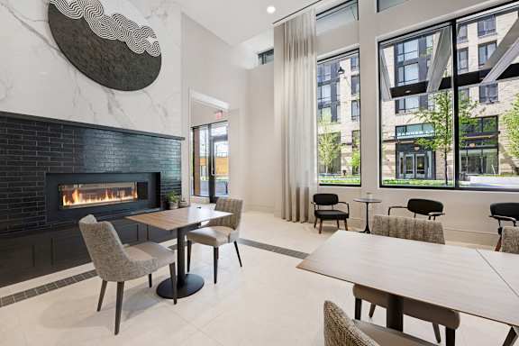 A modern dining room with a fireplace and a view of the city.