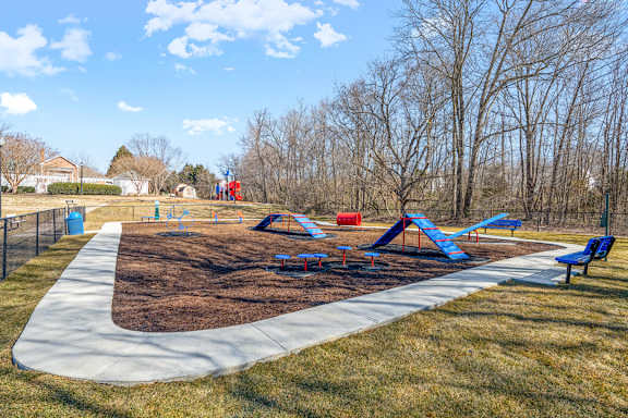 A playground with a blue slide and a red slide.