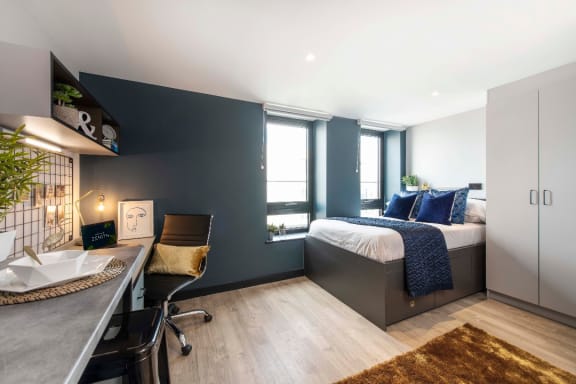 a bedroom with a bed and a desk in a hotel room