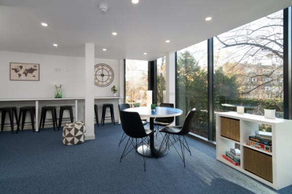 a room with a table and chairs and a large window