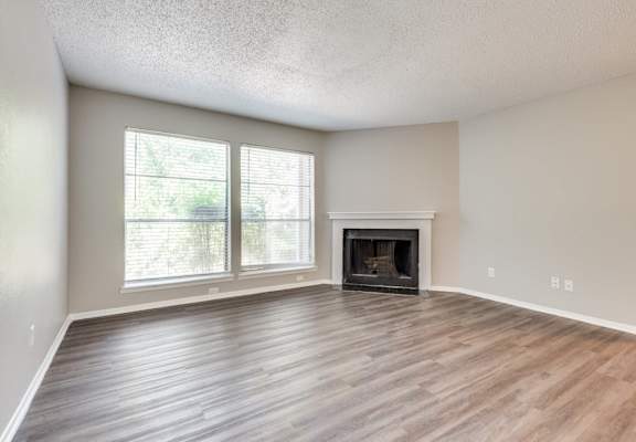A room with a fireplace and a window at Infinity on the Oaks Apartments, Dallas, TX