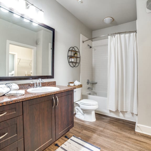 a bathroom with a large mirror and a shower and a toilet at The Landings at Brooks City-Base, San Antonio, TX, 78235