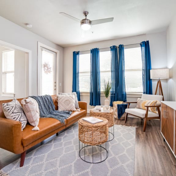 a living room with a couch and a dining table at The Landings at Brooks City-Base, San Antonio, TX