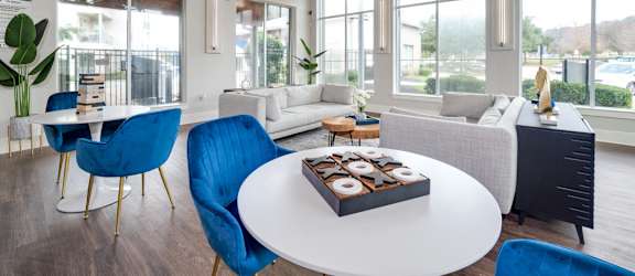 a living room with blue chairs and a white table at The Landings at Brooks City-Base, San Antonio