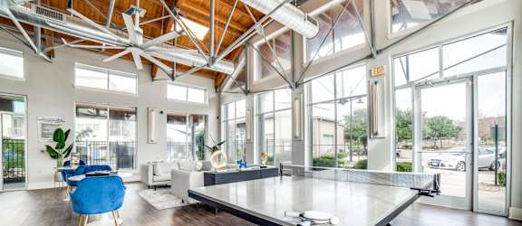 a large living room with a ping pong table at The Landings at Brooks City-Base, San Antonio