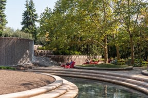 a water fountain with red chairs next to it