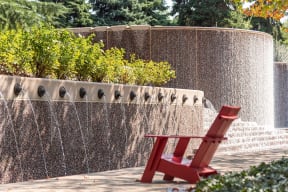 a red chair sitting in front of a water fountain