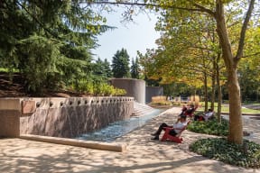people sitting on benches next to a water fountain