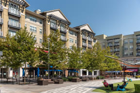 a view of a courtyard with trees in front of apartment buildings