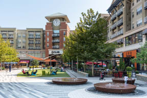 a city square with fountains and a clock tower