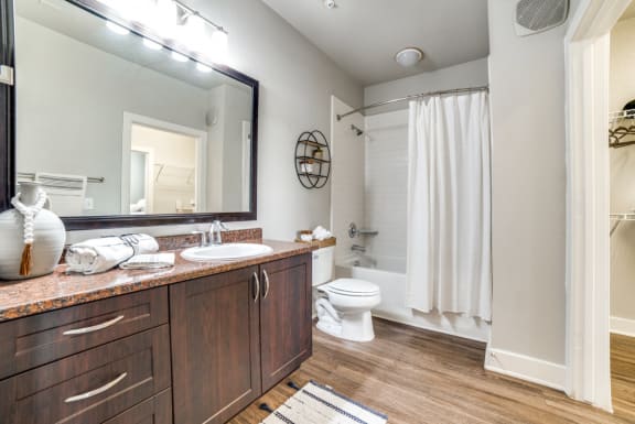a bathroom with a shower toilet and sink and a mirror at The Landings at Brooks City-Base, San Antonio, TX, 78235