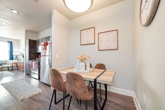 a dining room with a table and chairs and a kitchen at The Landings at Brooks City-Base, San Antonio, TX, 78235