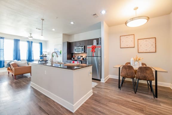 a kitchen and dining area with a stainless steel refrigerator at The Landings at Brooks City-Base, San Antonio, TX, 78235