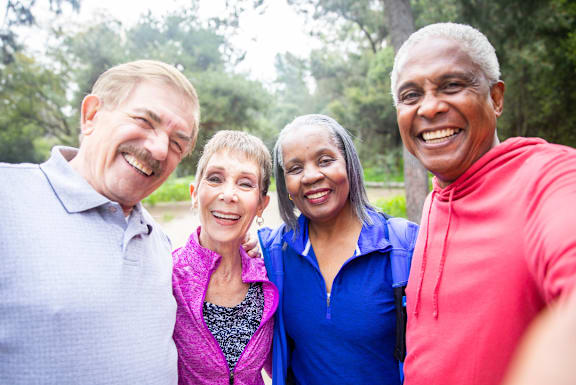 A group of four people standing together outdoors with a text overlay that reads