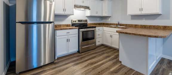 a kitchen with white cabinets and a stainless steel refrigerator
