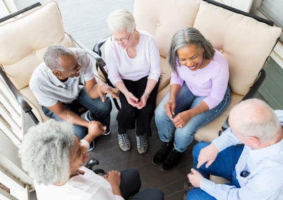 A group of people sitting on a couch in a circle.