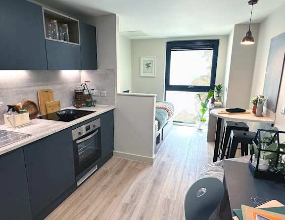 A kitchen with dark blue cabinets and a white countertop.