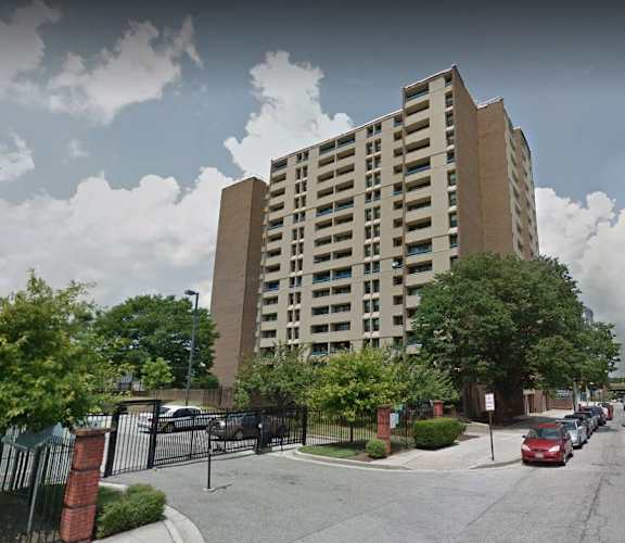 A tall building with a parking lot in front of it.