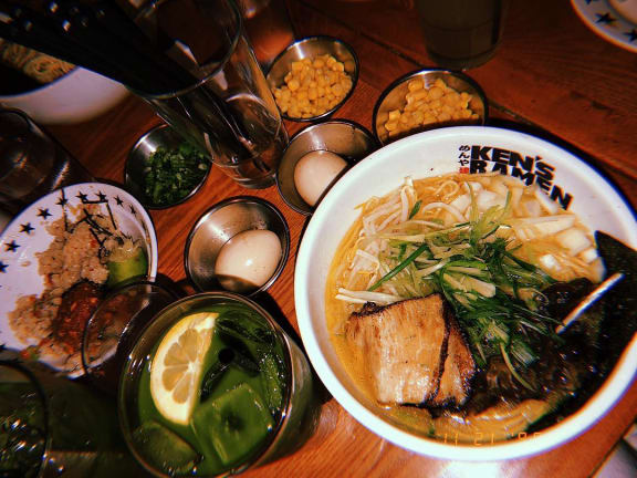 a bowl of ramen on a table with other bowls of food