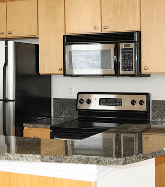A black microwave oven is mounted on a kitchen counter.
